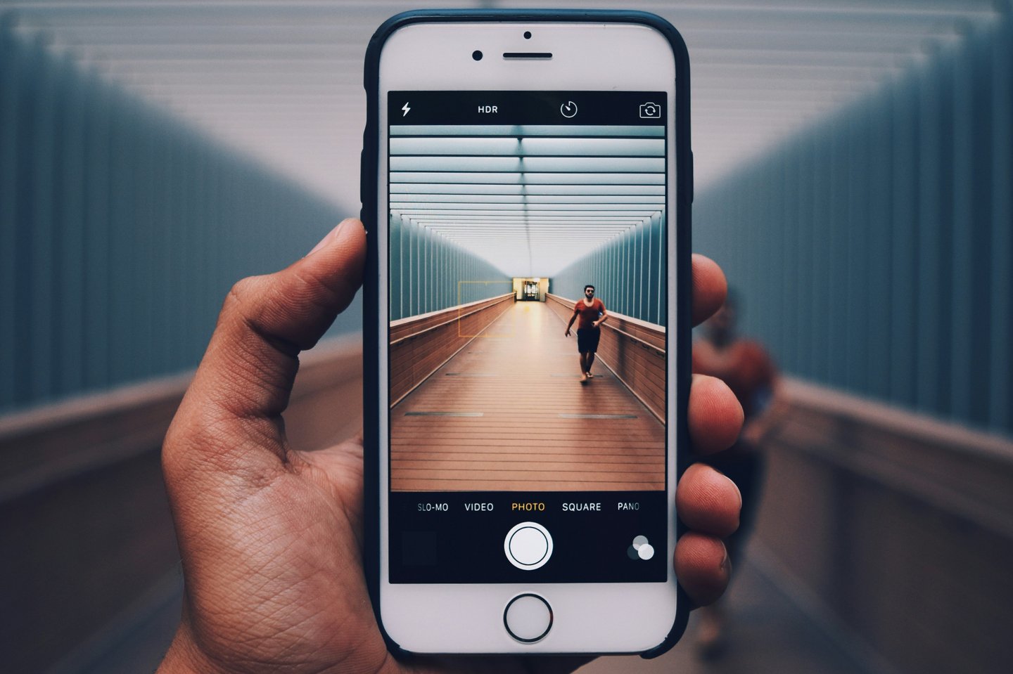eine Hand hält ein Smartphone und fotografiert damit
