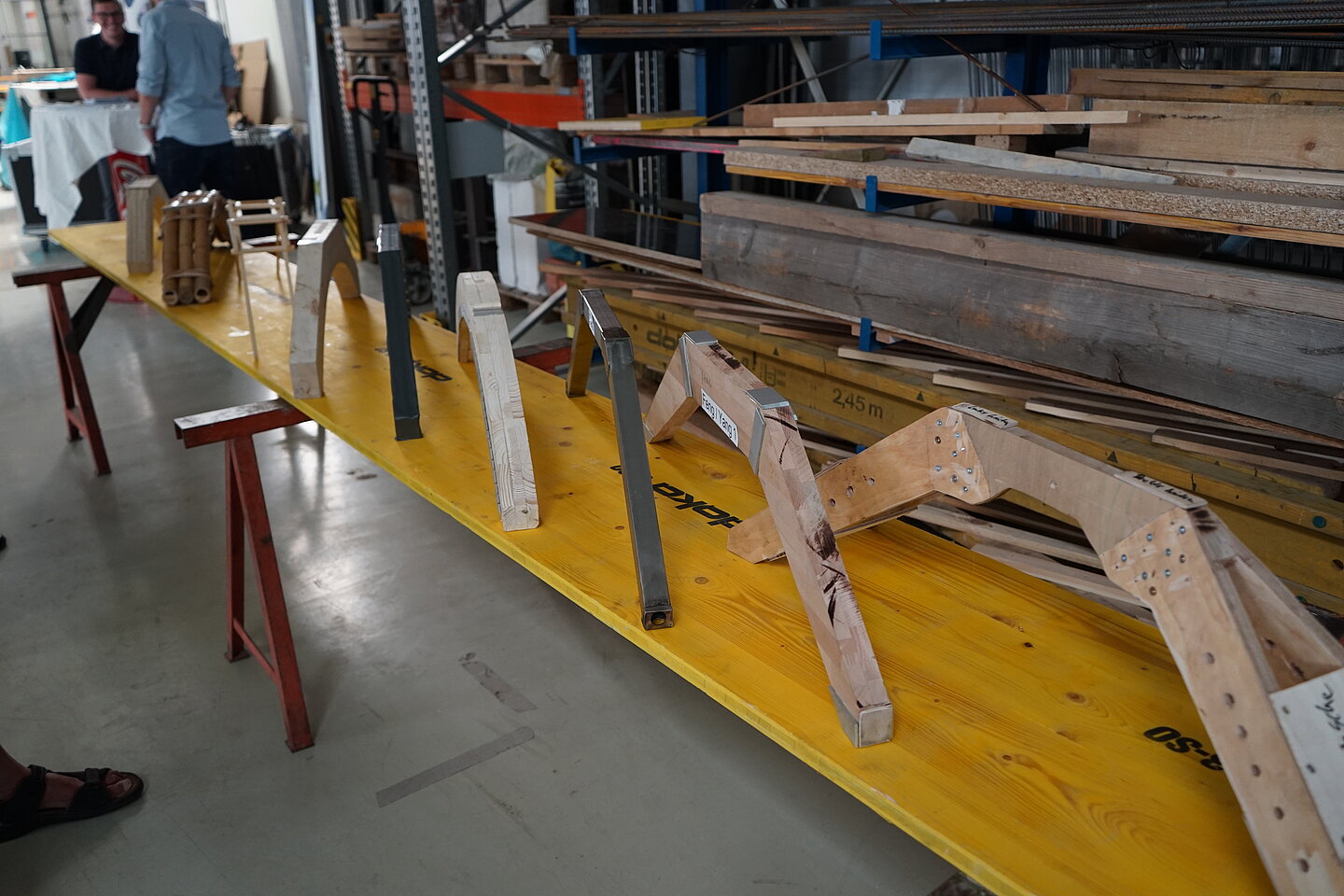 Neun Modelle kämpfen um den Sieg Neun Brückenmodelle stehen der Reihe nach auf einem Holztisch