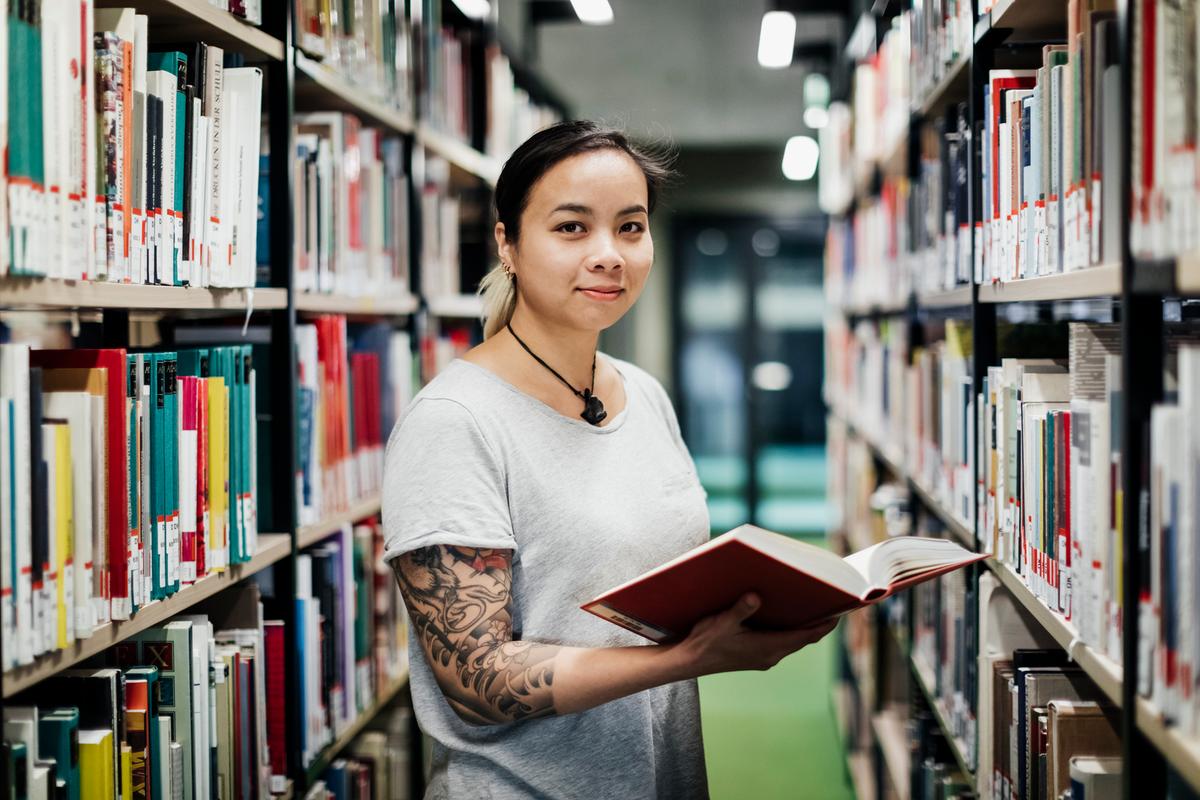 Eine Frau hält ein Buch in der Hand.